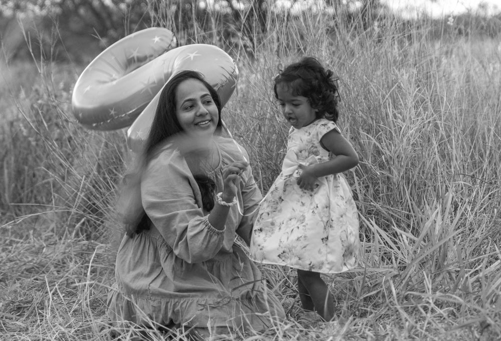 A black and white portrait showing a tender moment in a field.