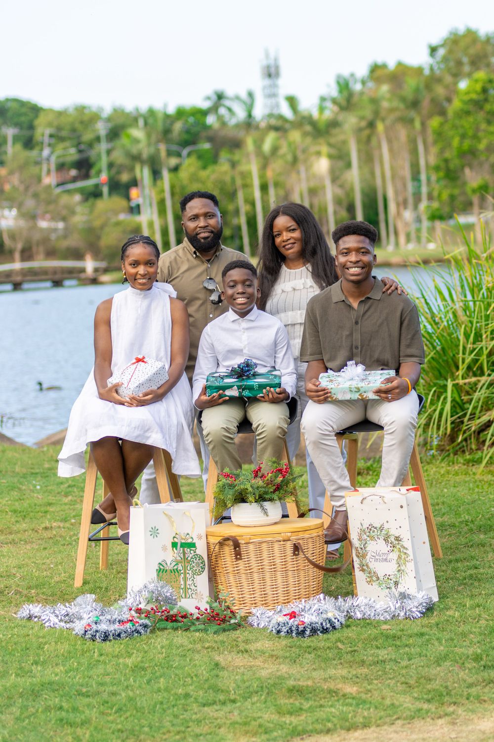 Outdoor family portrait session with coordinated outfits and picnic staging by waterfront.