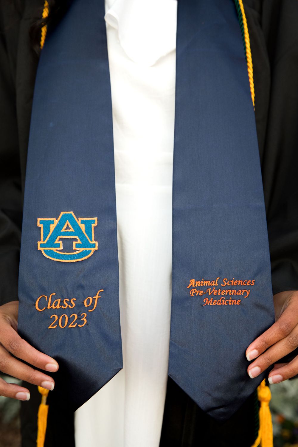 African American girl holding Auburn University class of 2023 lapel on Samford Lawn on the campus of Auburn University