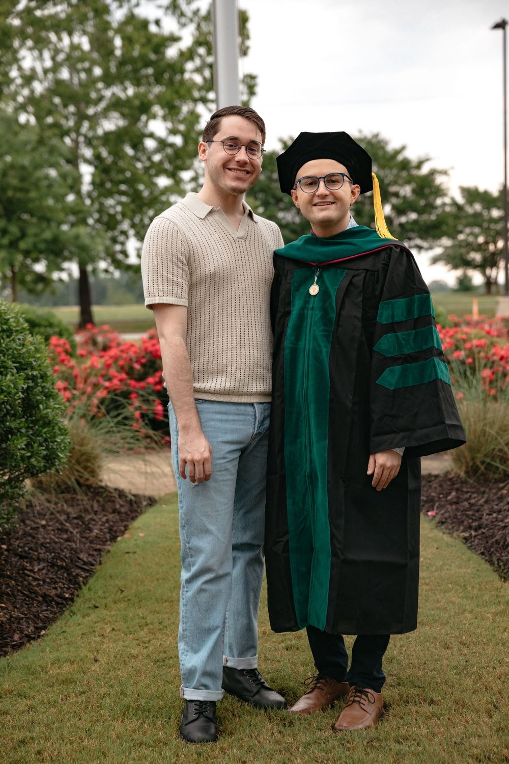 male graduate and partner in front of VCOM-Auburn medical school on the campus of Auburn University LGBTQ