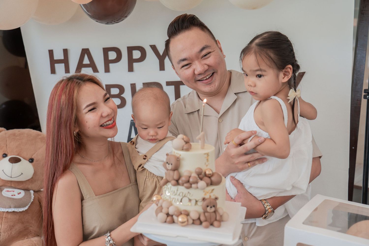 Family gathered around birthday cake at celebration party.