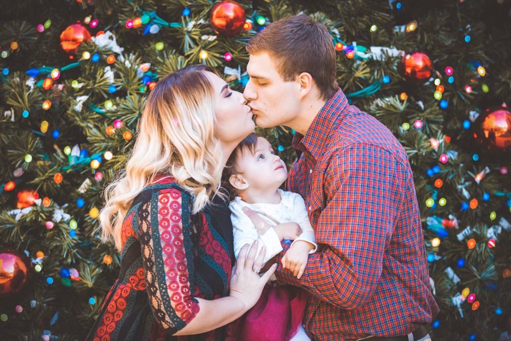 A beautiful family is posing for photo in Knoxville TN Christmas photograph in Downtown knoxville