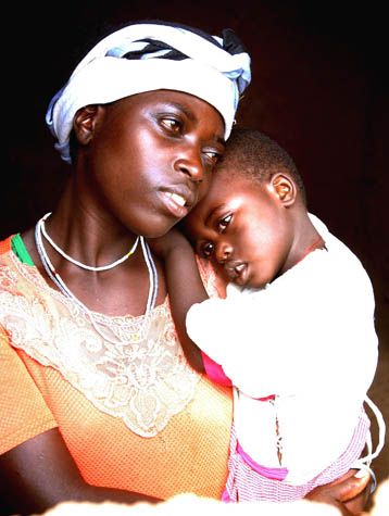 Portrait of parent and child in intimate pose against dark background.