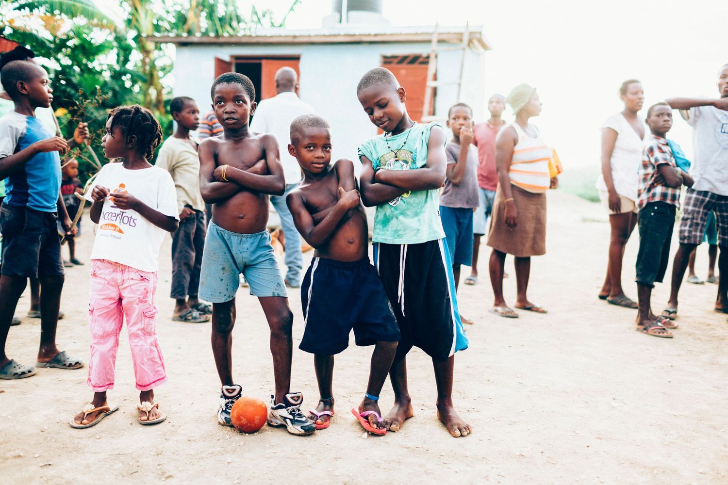 Haitian kids playing soccer outside in village in Haiti