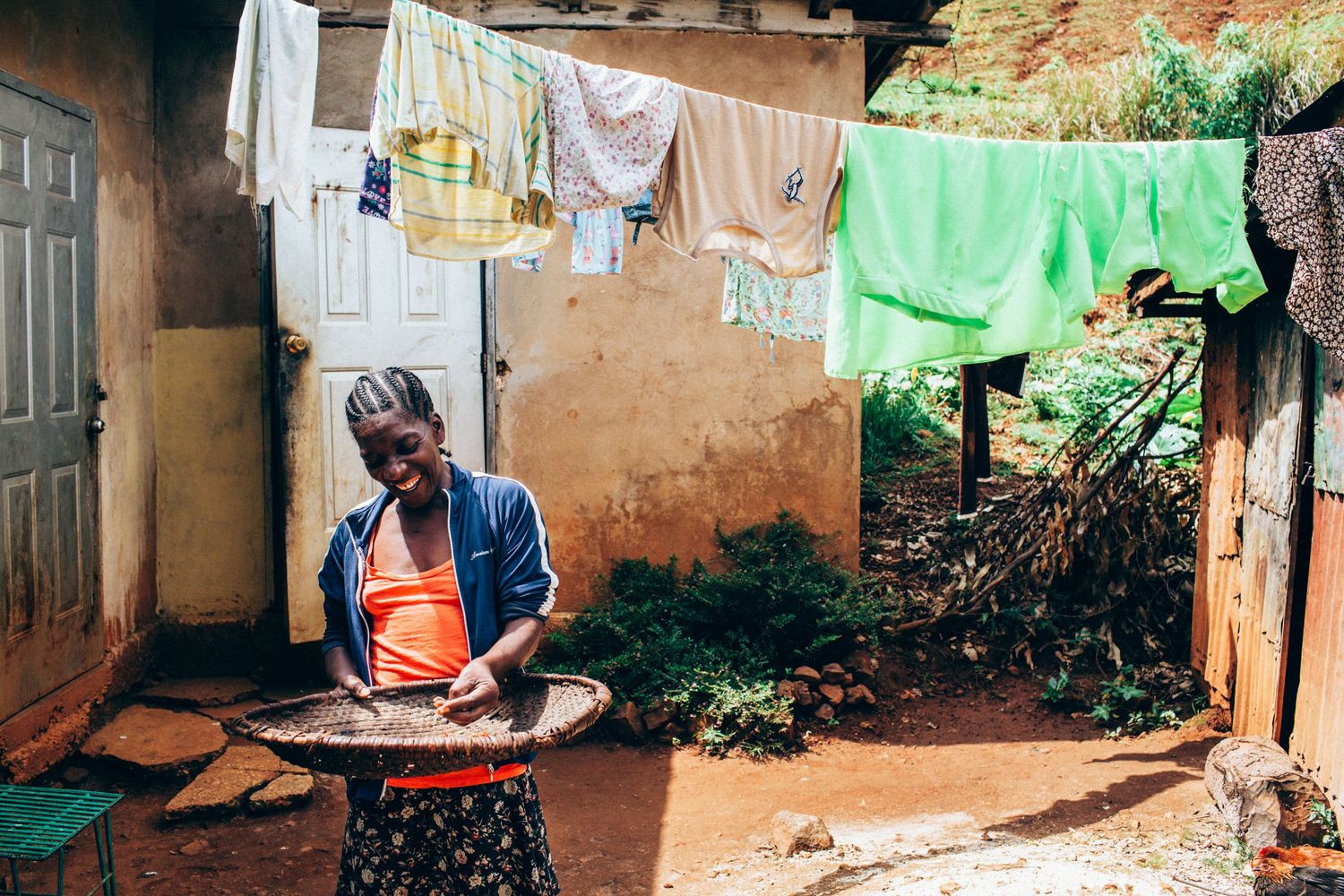 Female Haitian coffee farmer sorting coffee beans outside her house in the mountains of Haiti
