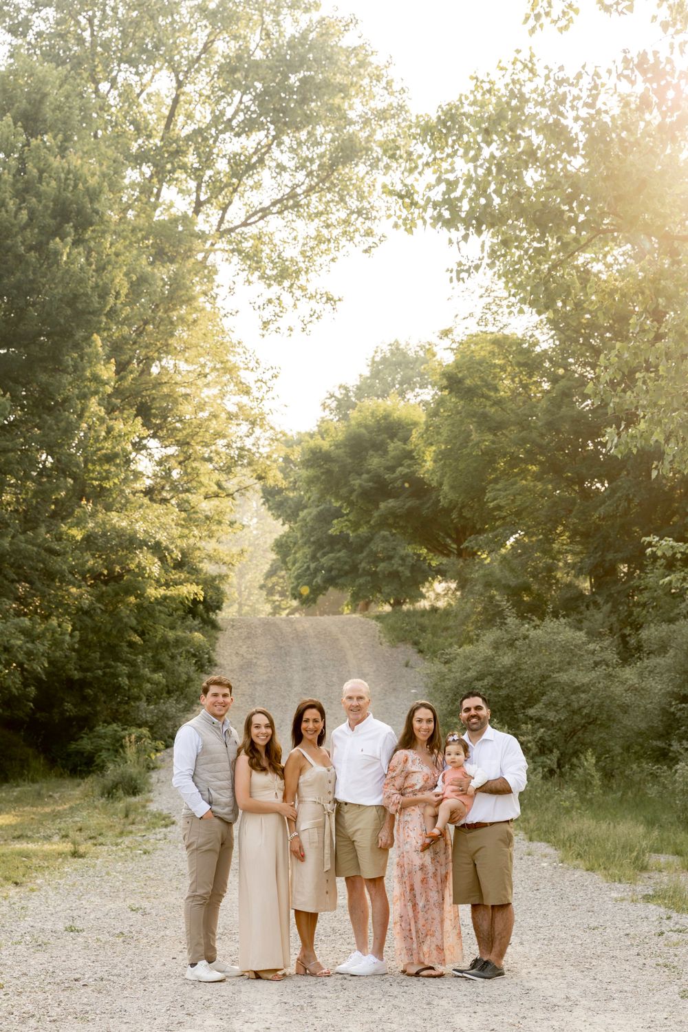 extended family standing in front of a gravel hill at river bends park in Shelby township
