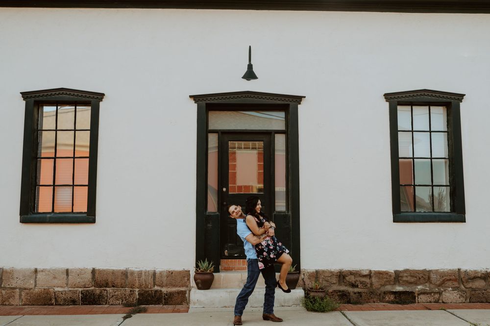 A long white wall with multiple dark wooden windows and doors in a row.