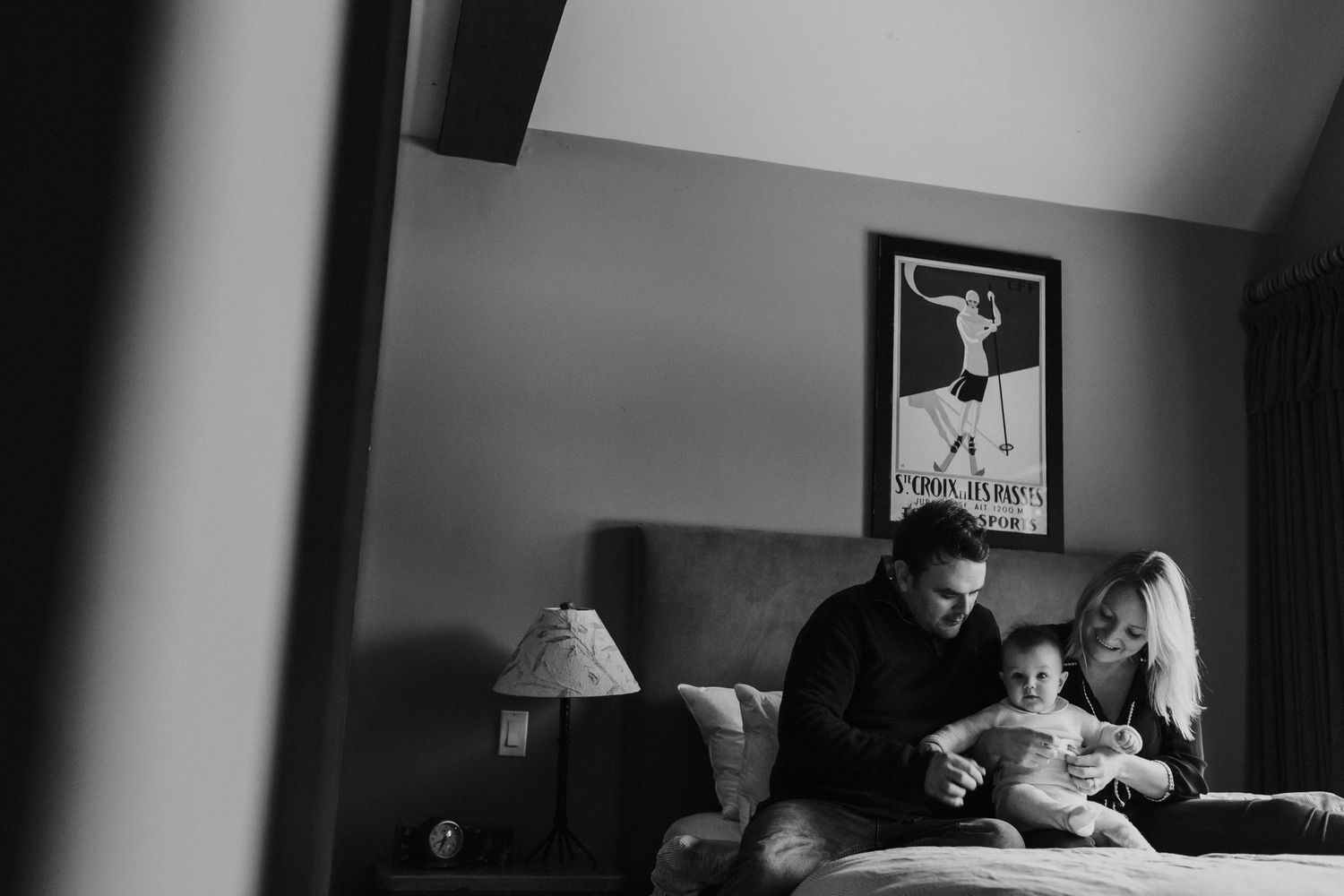 A couple with their baby on their bed.