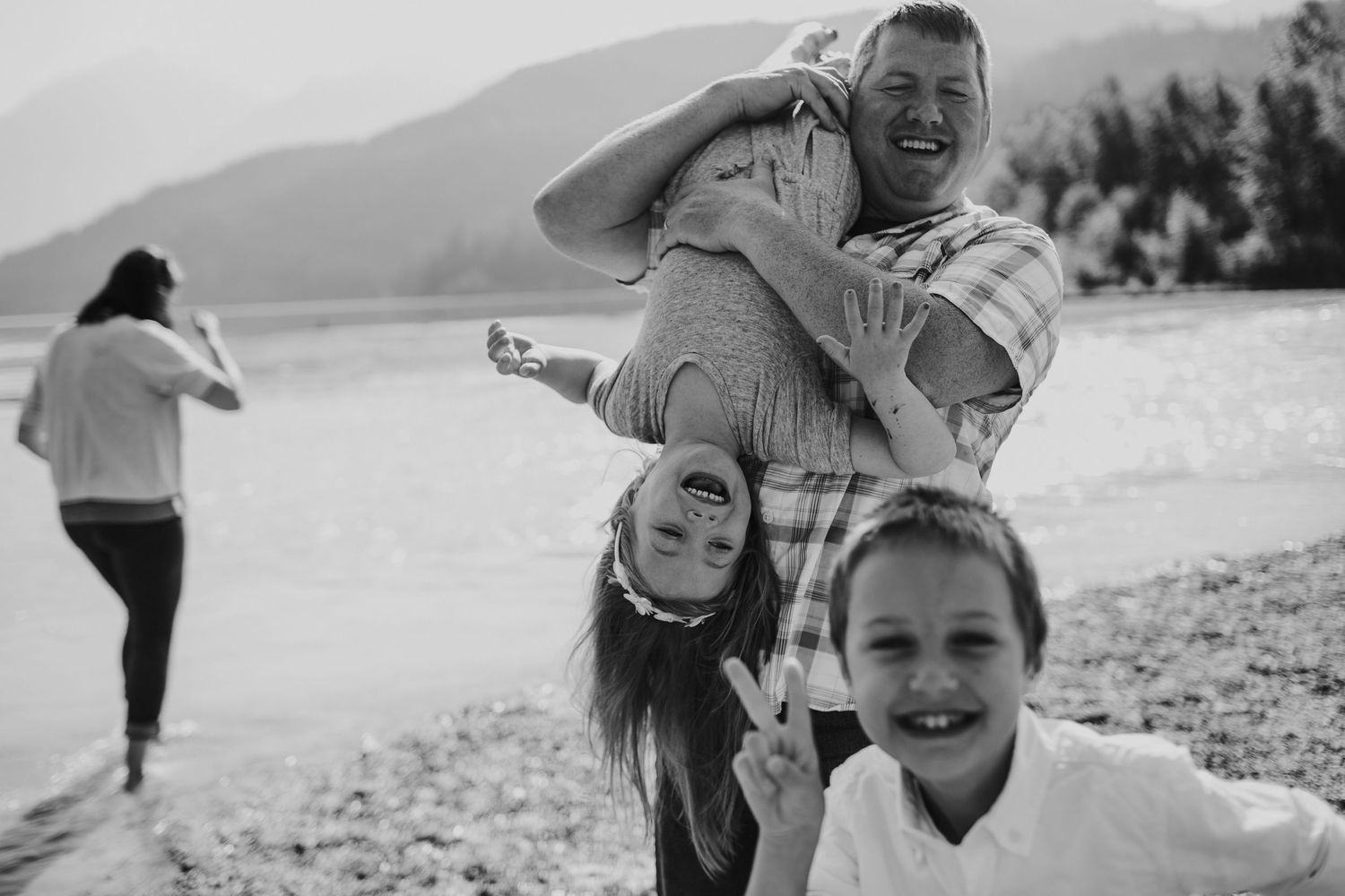 A family plays together at Green Lake during a family photoshoot.