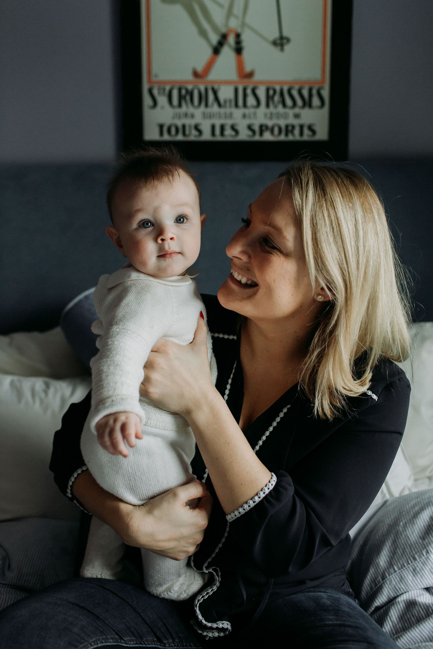 A mother holds her young son on a couch.