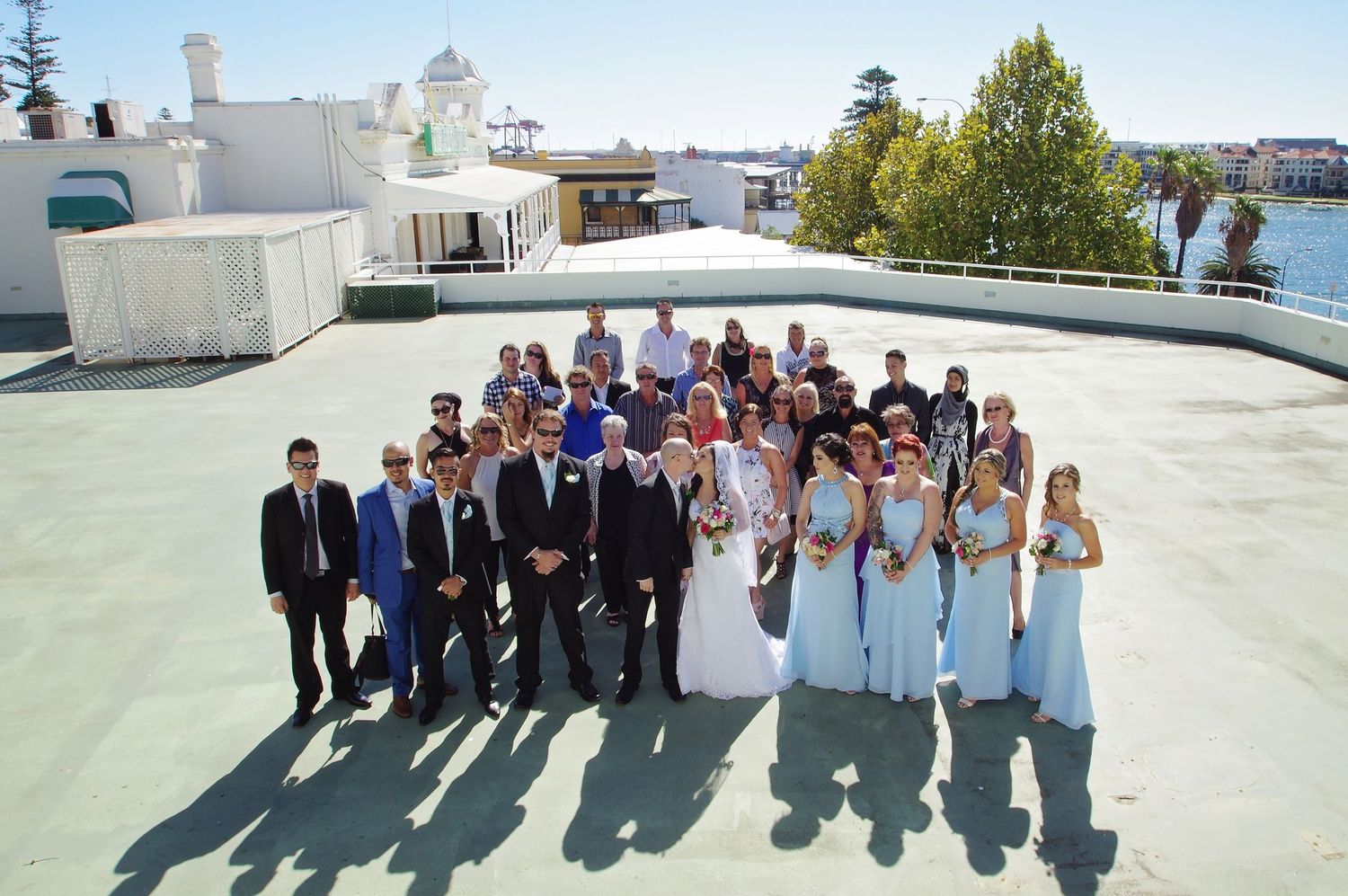 group shot of bride and groom and guests on rooftop