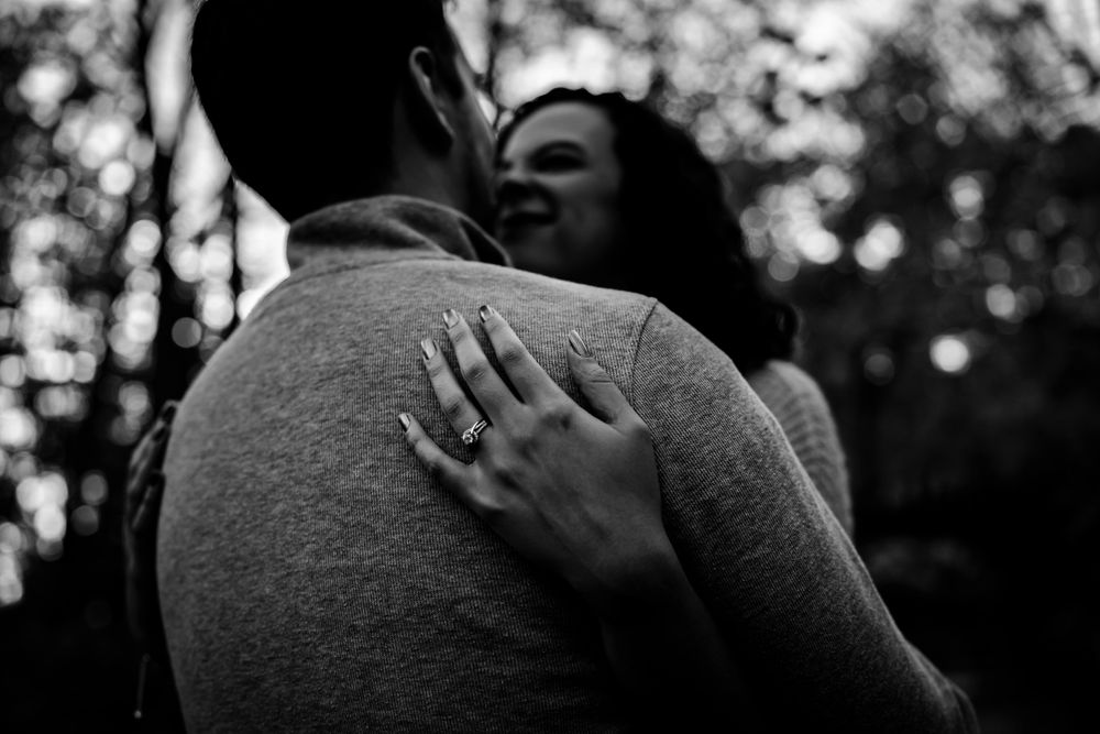 Black and white intimate portrait of a couple embracing in natural lighting.