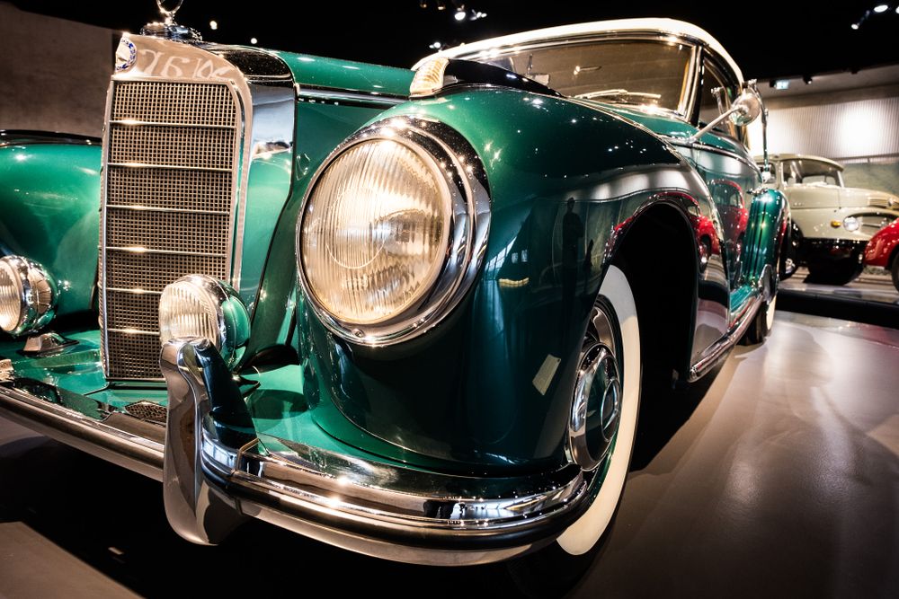 Stunning vintage teal green Mercedes-Benz 300S classic car on display at an automotive museum showroom.