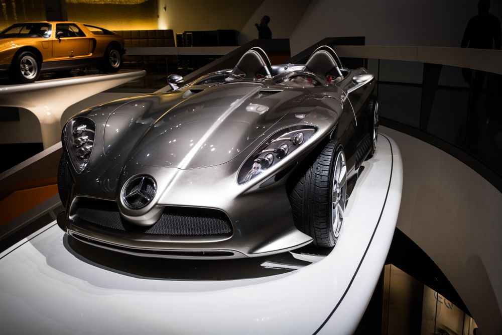 Sleek silver Mercedes-Benz concept car on display at an automotive museum exhibition.
