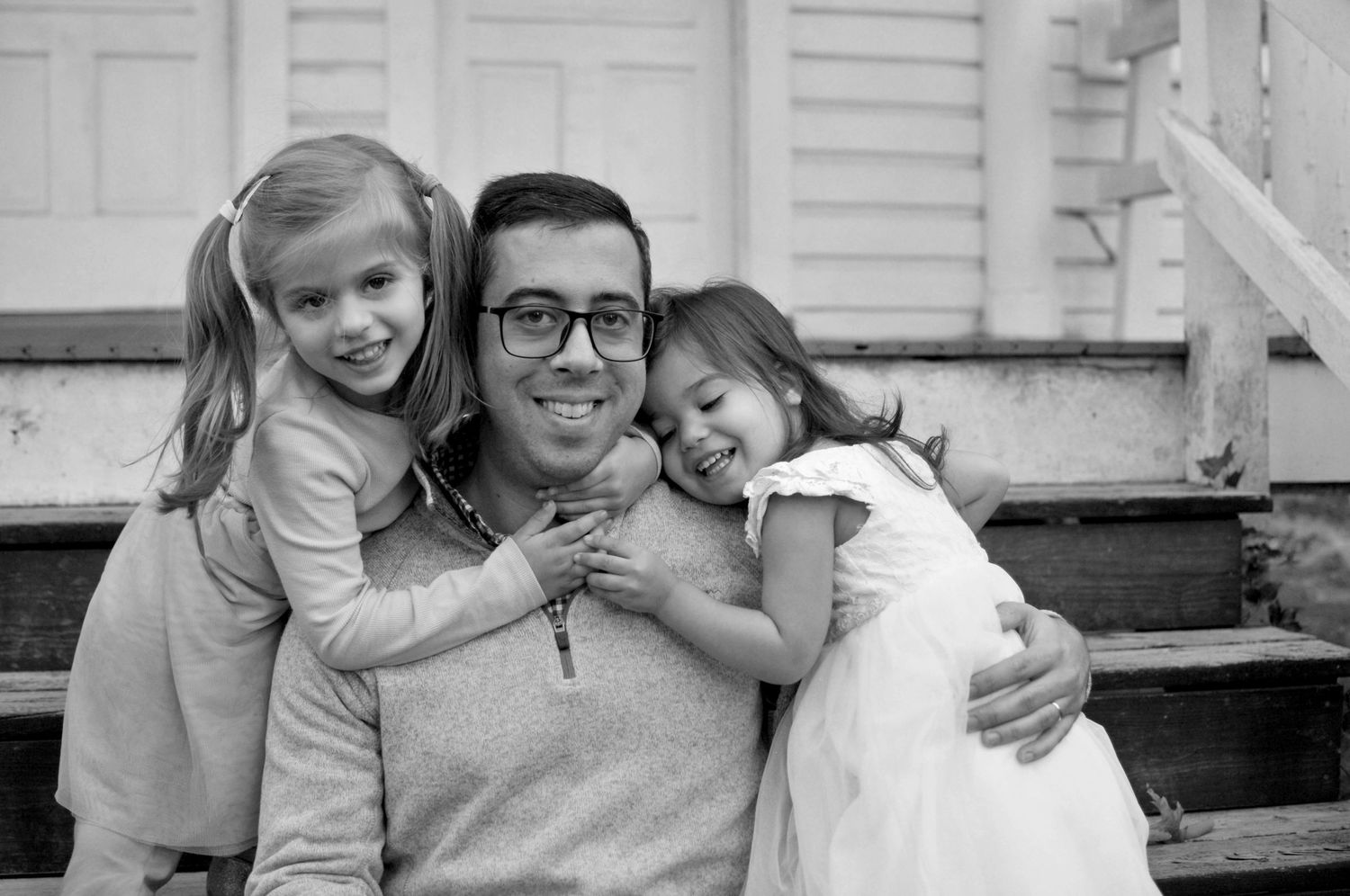 black and white photo of dad with two young children at Claude Moore Park