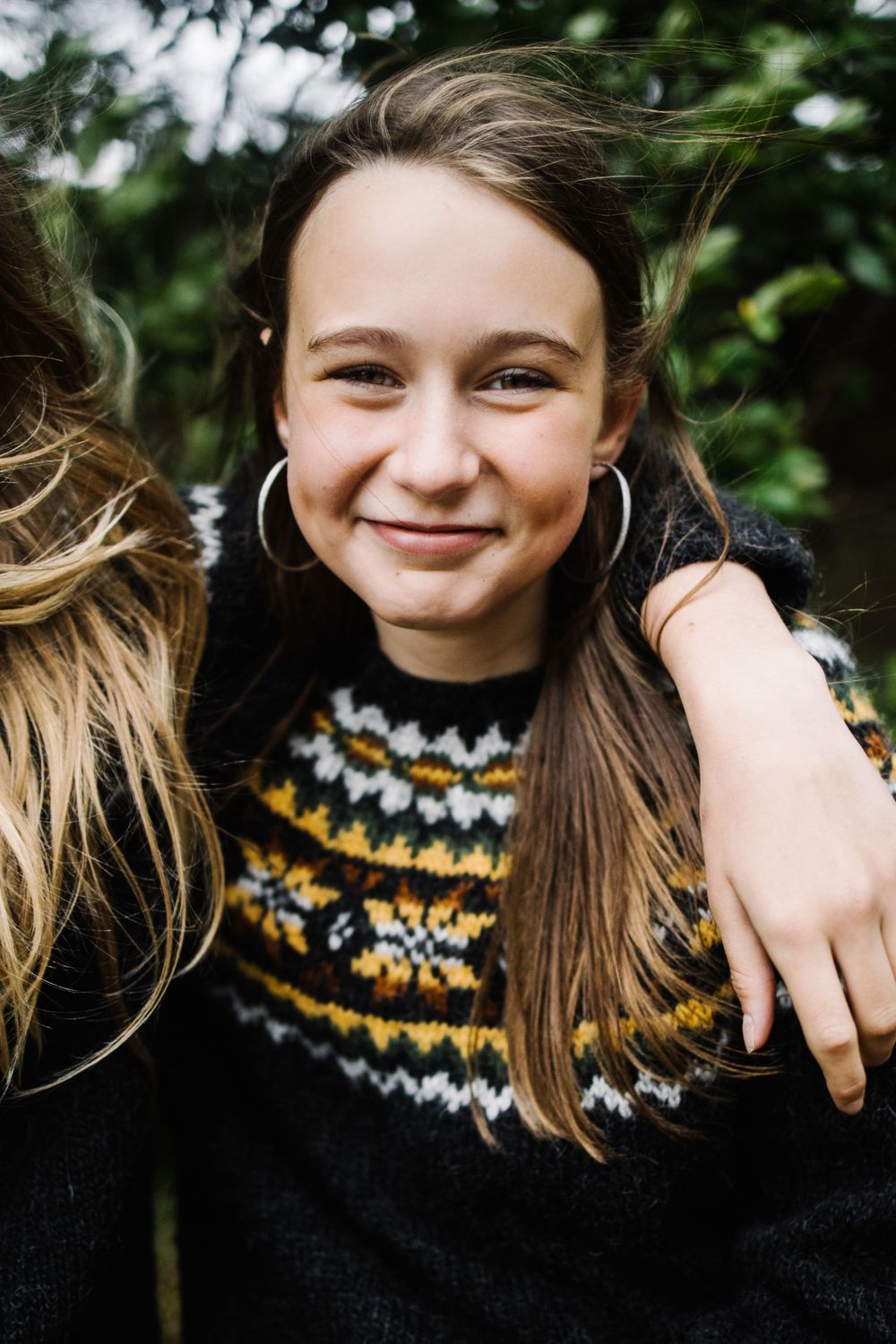 Person wearing black and yellow fair isle pattern sweater outdoors.