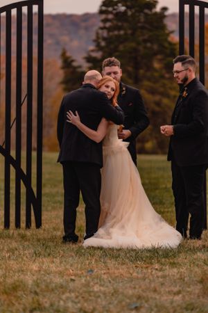 Wedding couple sharing intimate moments near decorative black metal gates at sunset.