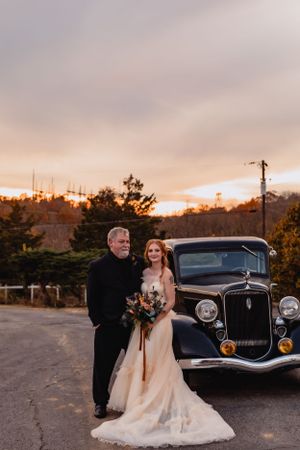 Wedding portraits with a classic vintage car during golden hour.