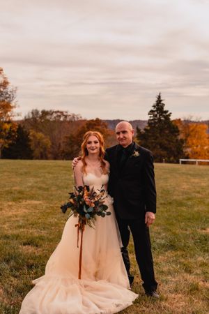 Autumn wedding photos in a field with warm sunset lighting and natural scenery.
