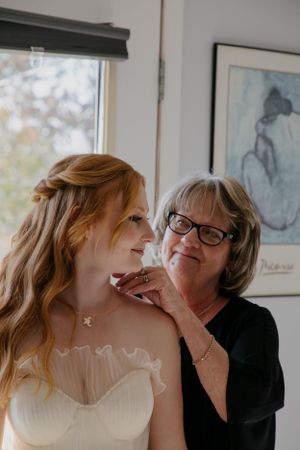 Indoor wedding preparation moments captured with natural window lighting.