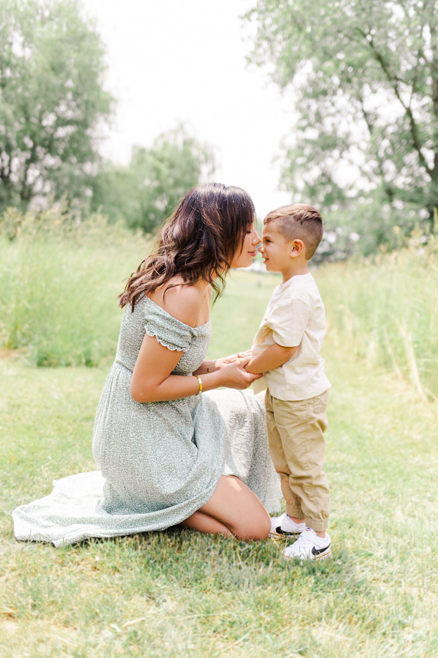 Mother and son touching noses in a grassy pathway during a Hudson Valley spring family session