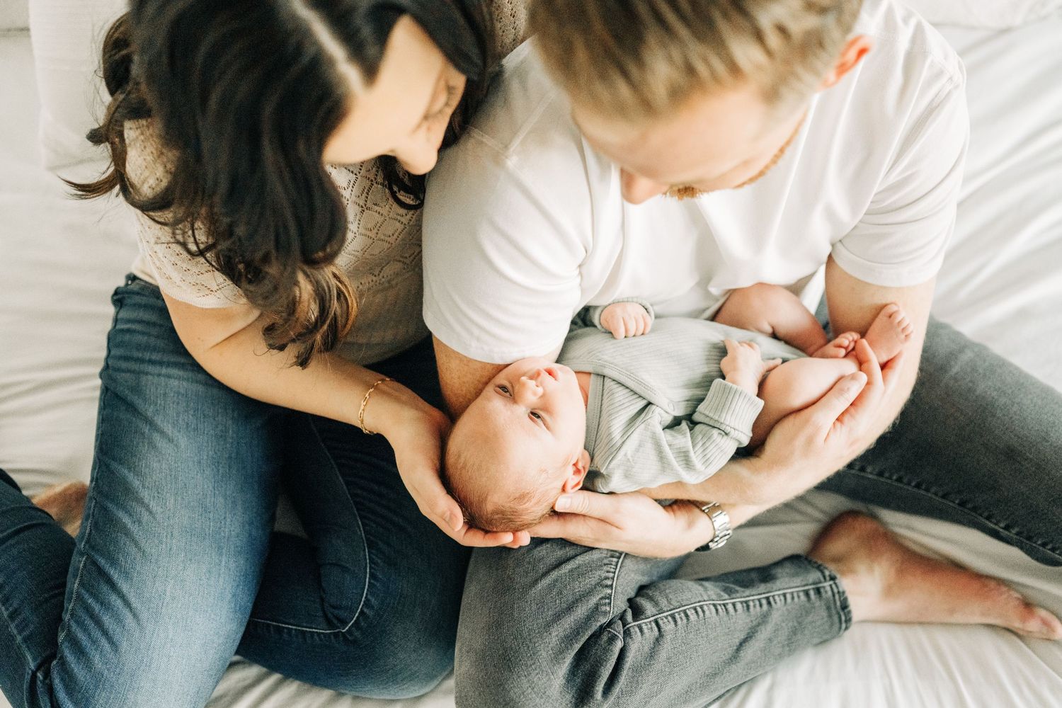 Mom and Dad cuddling newborn during photo session in Frisco, TX