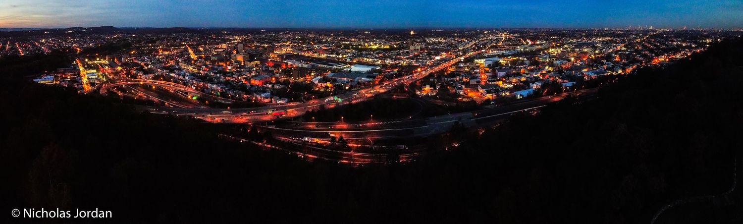 Sunset aerial panorama of city lights stretching across the horizon.