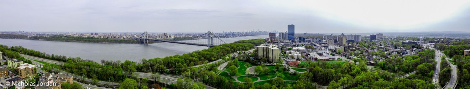 Wide aerial panorama of urban landscape with buildings and infrastructure.