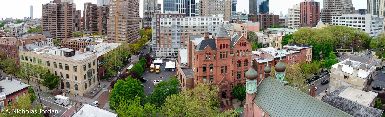 Aerial cityscape showing urban buildings and architecture with green spaces.