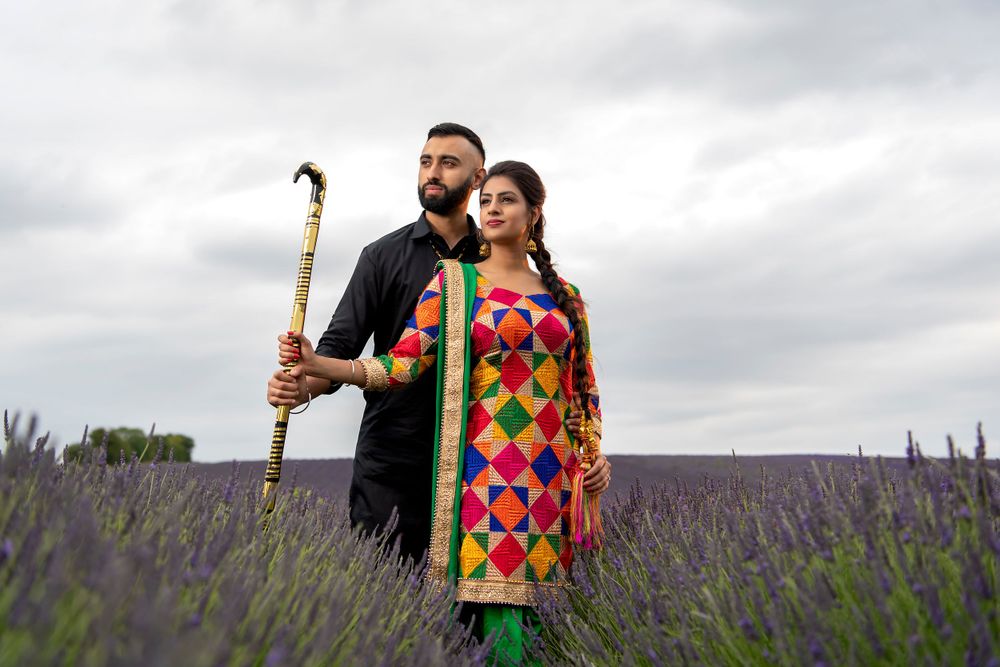 Couple poses in a blooming lavender field on an overcast day.