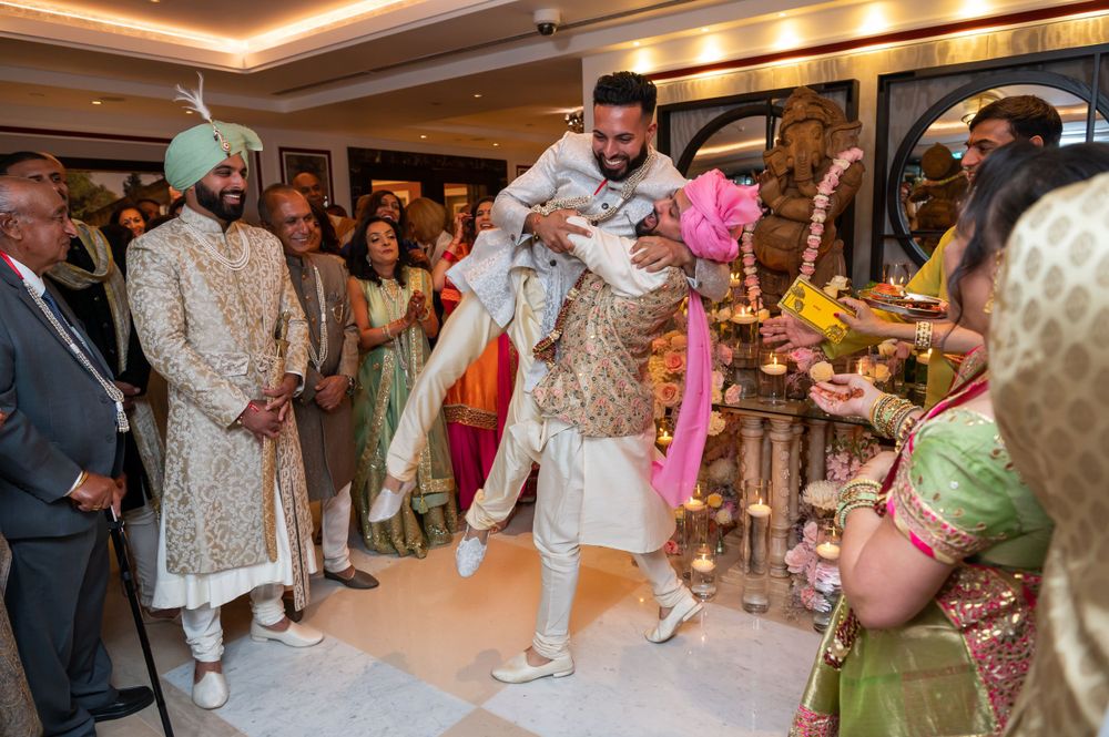 Festive wedding reception with guests dancing and celebrating in an ornate ballroom.