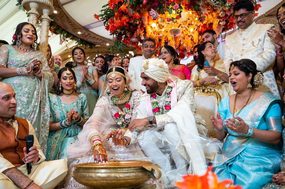 Bride and groom playing Koda Kodi games at North Mymms Park by Foto Collective, laughing with family in matching teal wedding outfits.