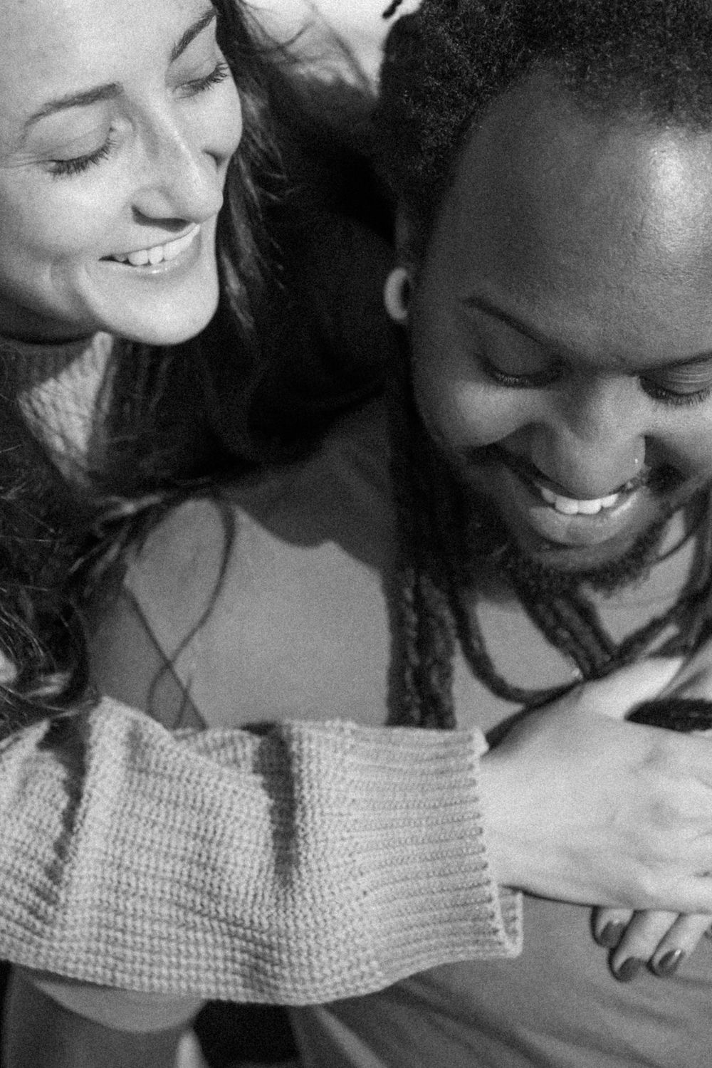 Black and white photo showing a candid moment of shared joy and laughter between two people.