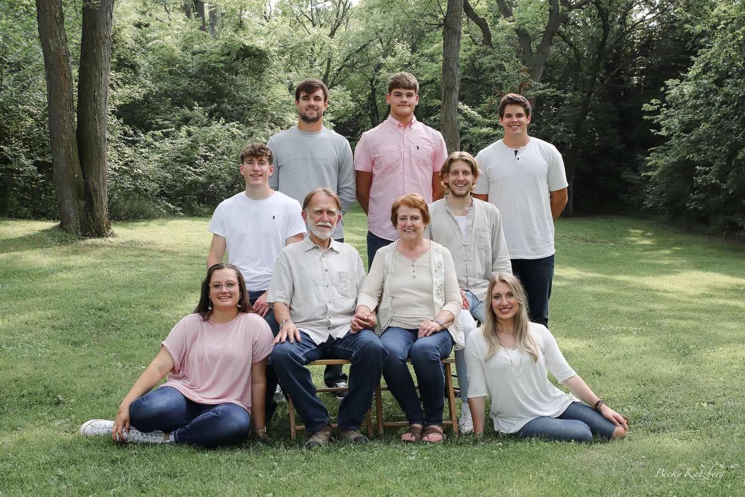becky katzberg photography family summer photo in a grassy field with tall trees in the background