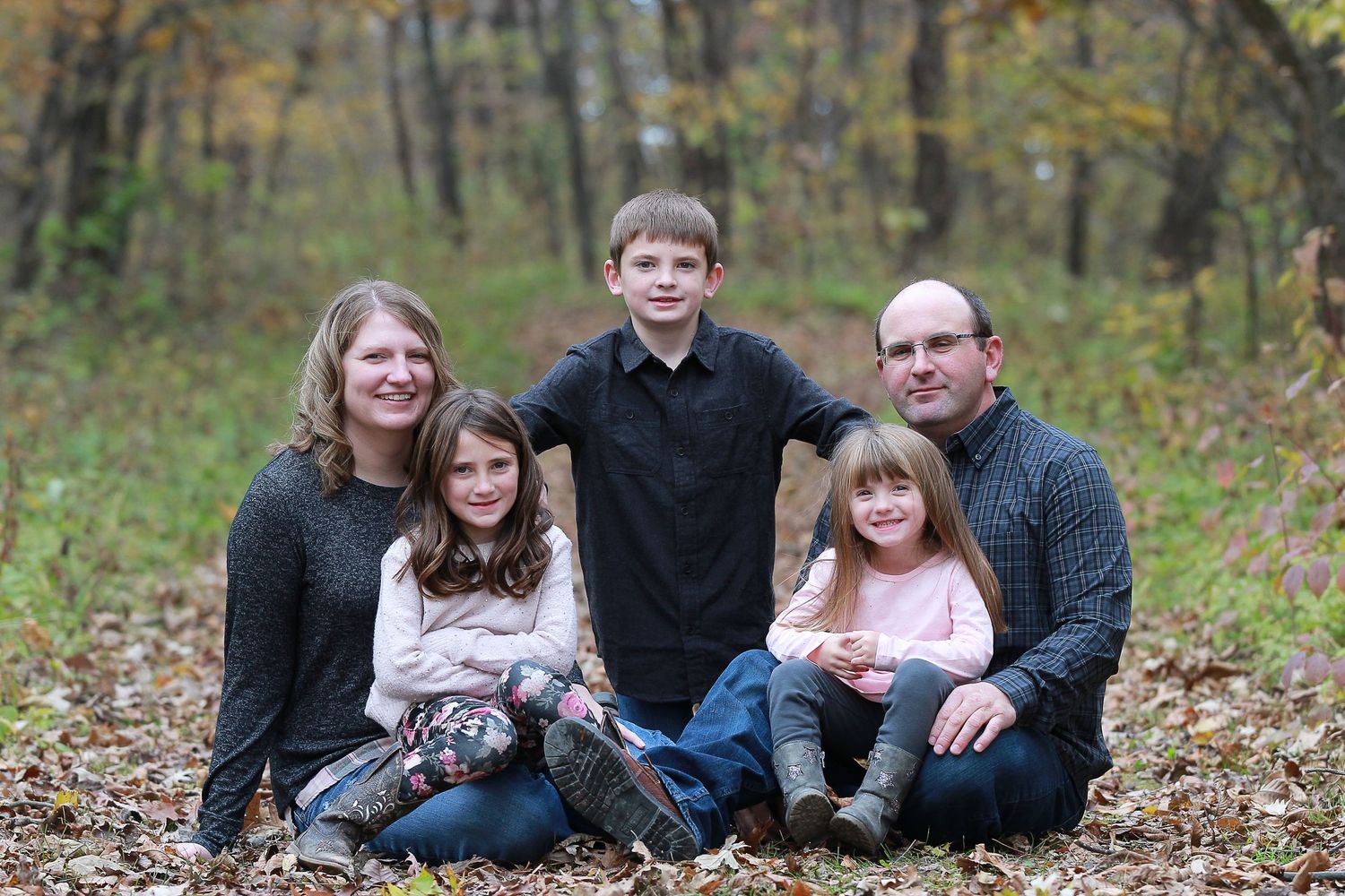 becky katzberg photography family fall photo in a leafy trail in a wooded area