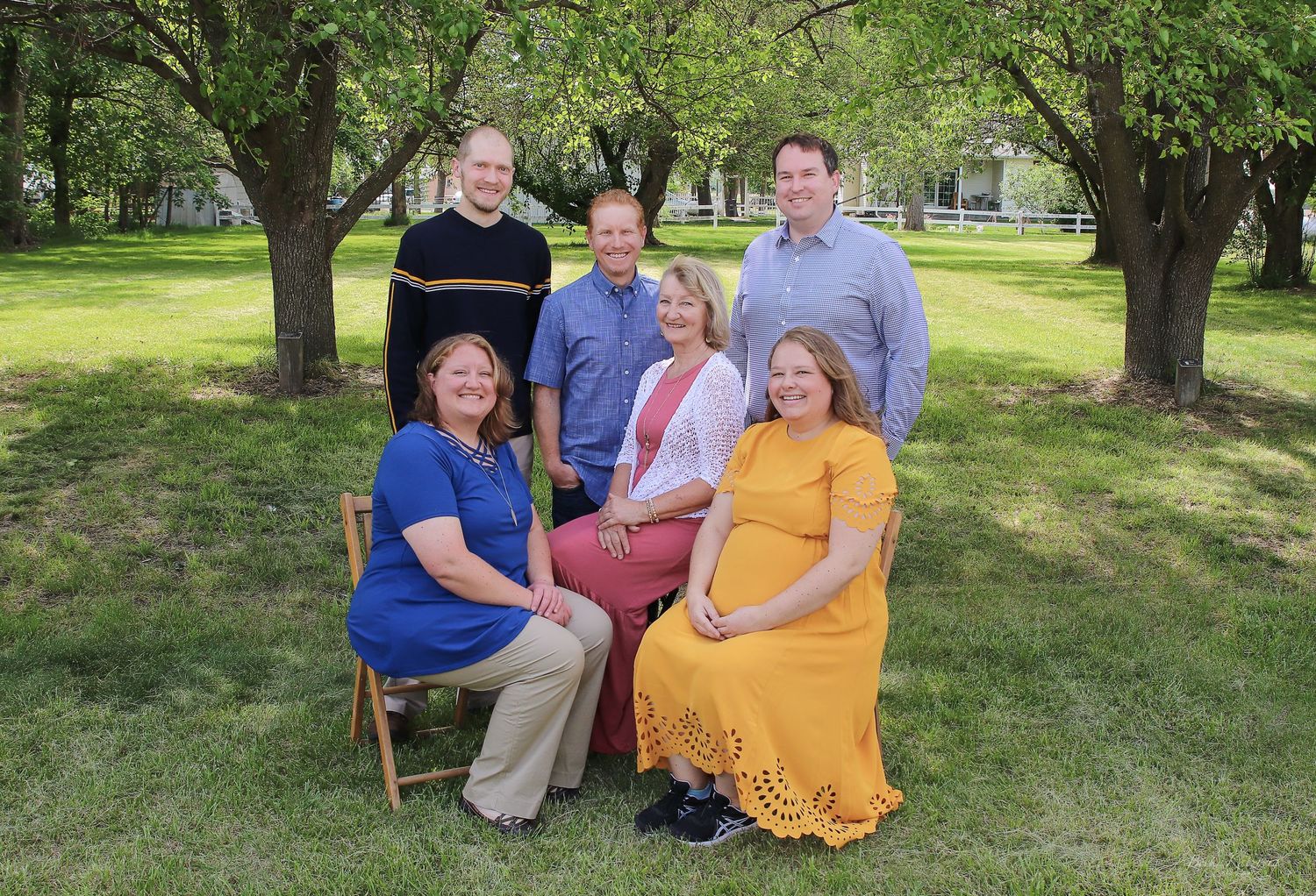 becky katzberg photography family summer photo in a grassy yard with tall trees in the background