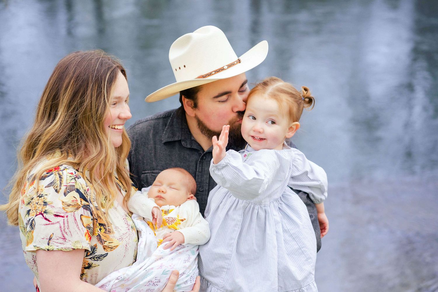 family of 4 with newborn girl by the river
