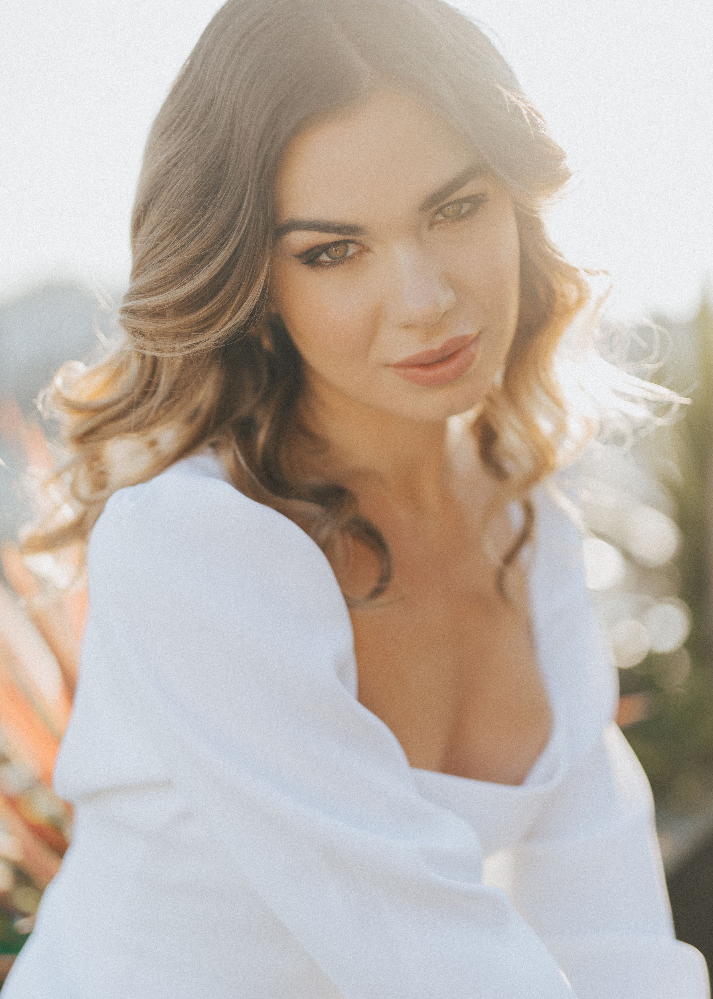 Romantic portrait series in soft lighting with white outfit and flowing hair.