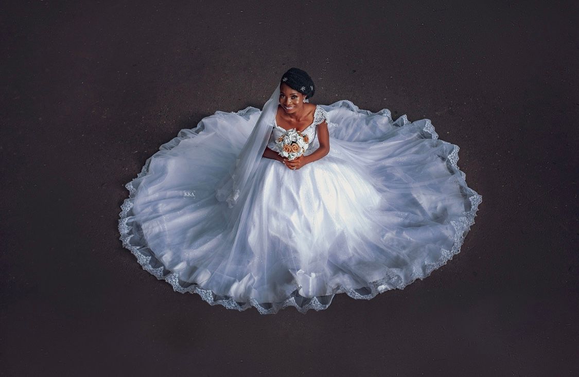 Aerial view of bride in white ball gown against dark background.