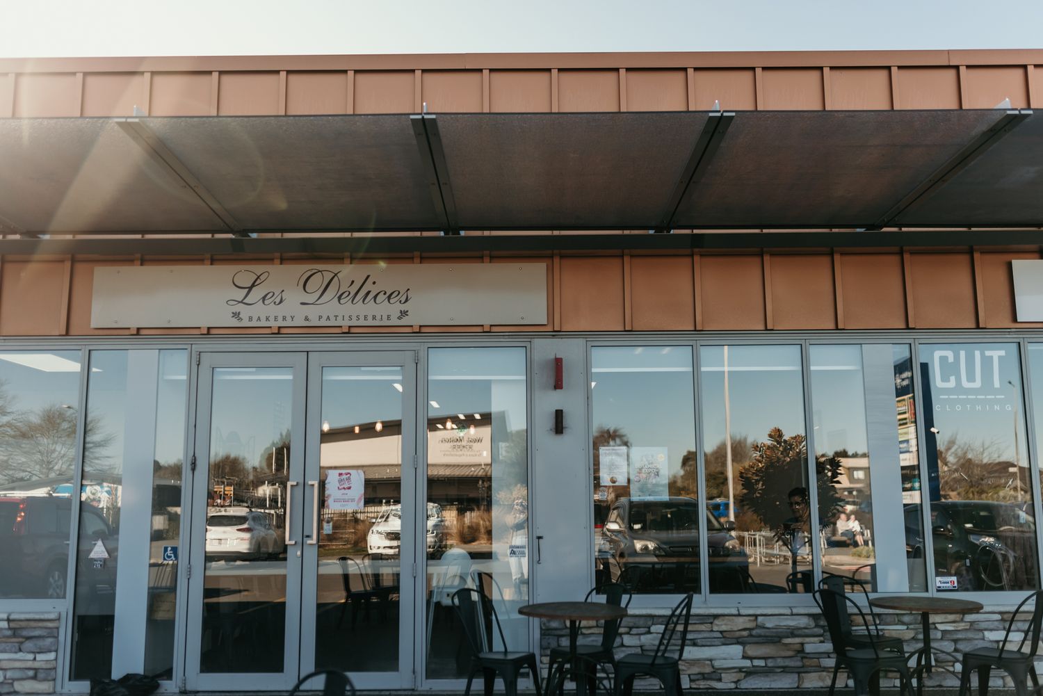 Exterior storefront of La Petrie bakery with outdoor seating and glass windows.