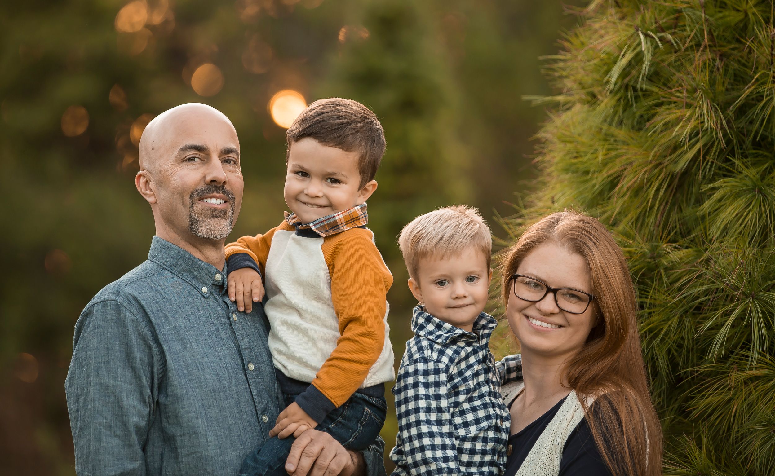 Family portrait session in field during golden hour sunset.