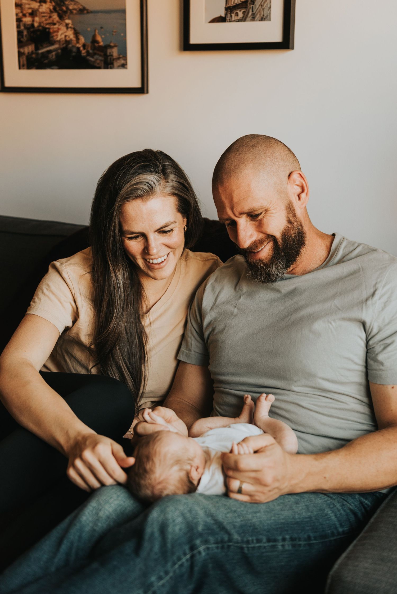 A couple shares intimate moments of joy while sitting on a couch together.