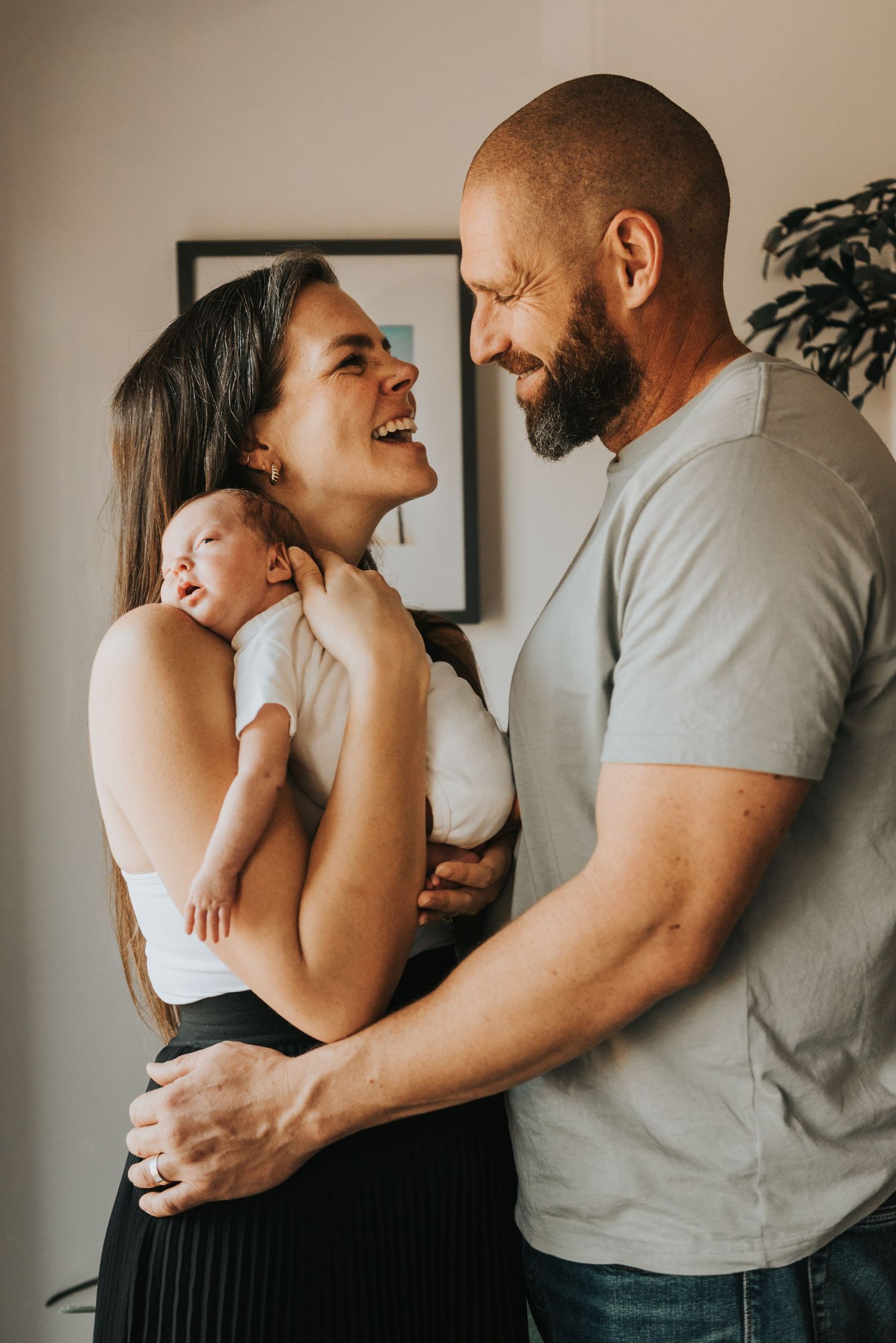 Candid lifestyle photos of a couple laughing and embracing in a bright indoor setting.