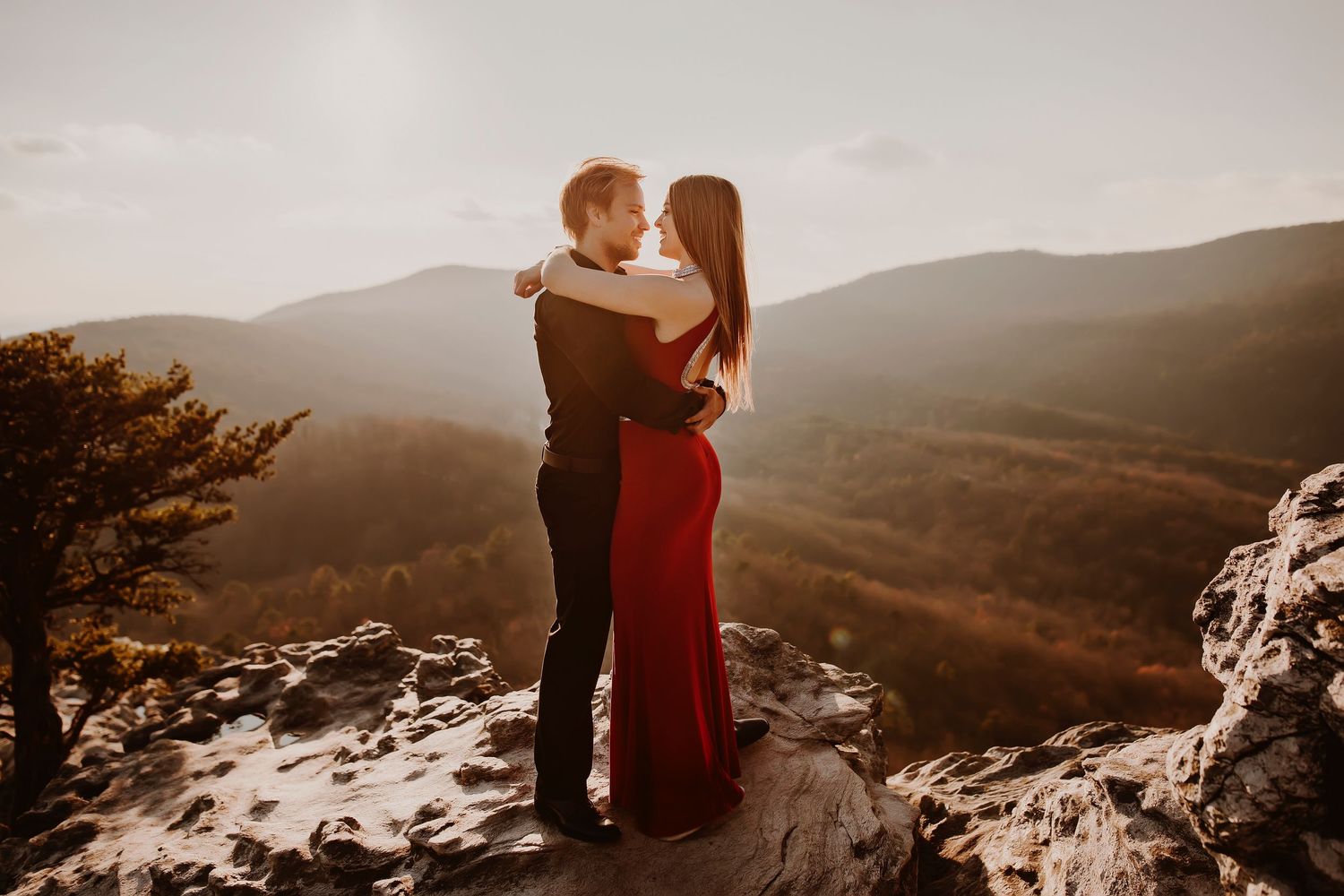 A romantic mountain-top embrace with snow and rolling hills in the background.