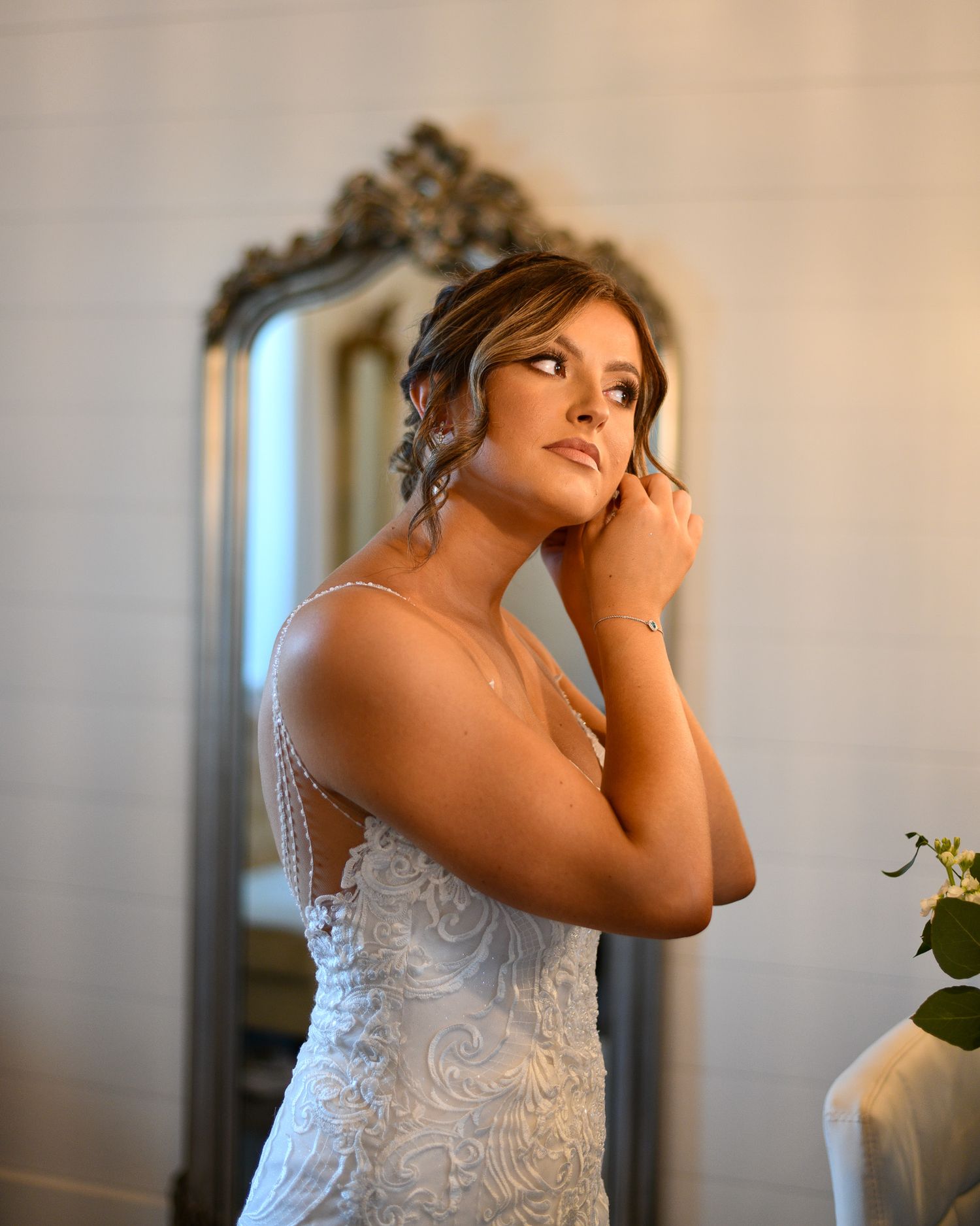 Bridal portrait captured in soft lighting with ornate mirror in background.