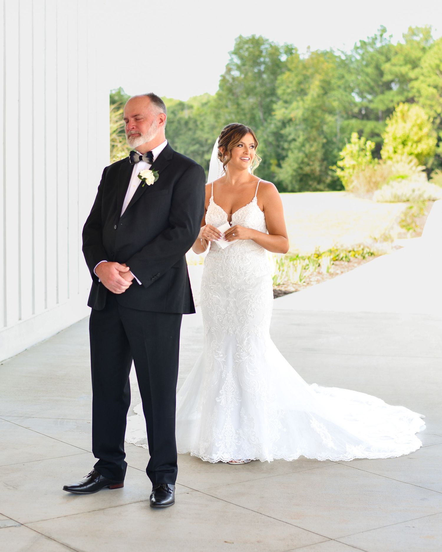 First look moment between wedding couple on white columned porch.