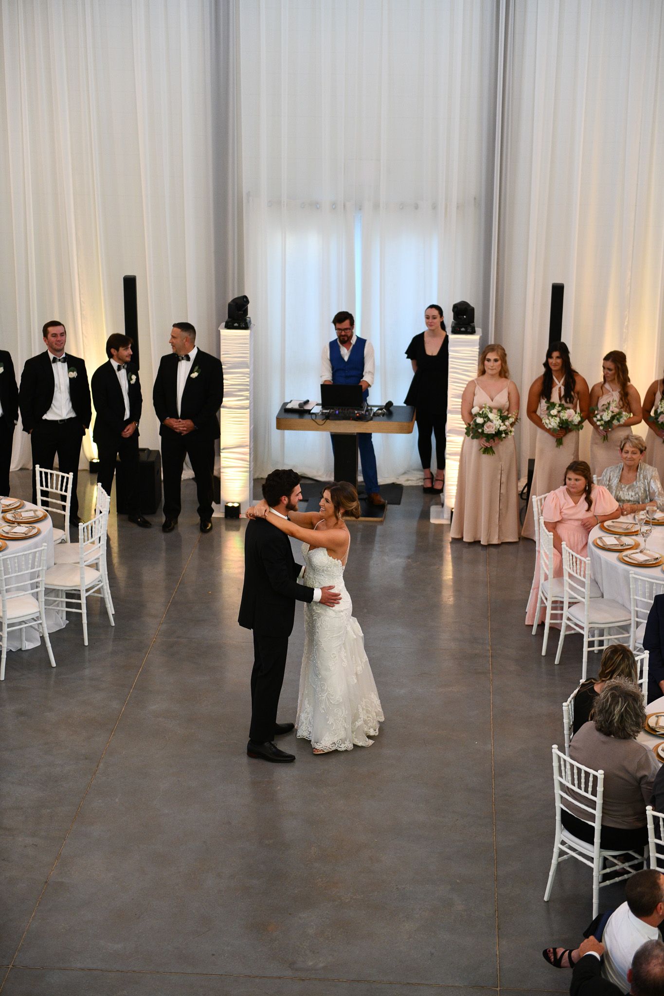 Wedding reception in a modern venue with guests dancing and celebrating.