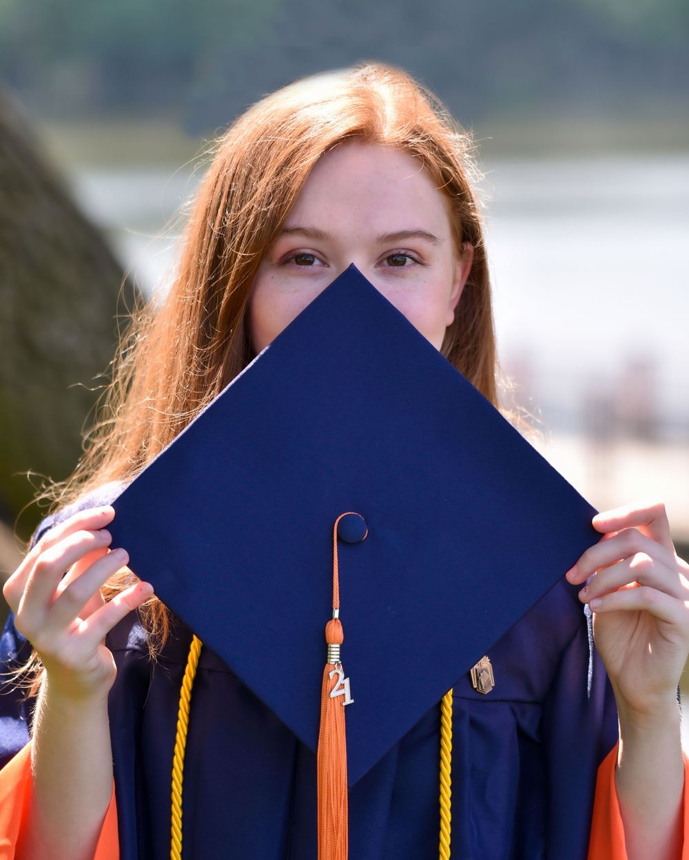 Series of shots showing graduate playfully hiding behind blue graduation cap.