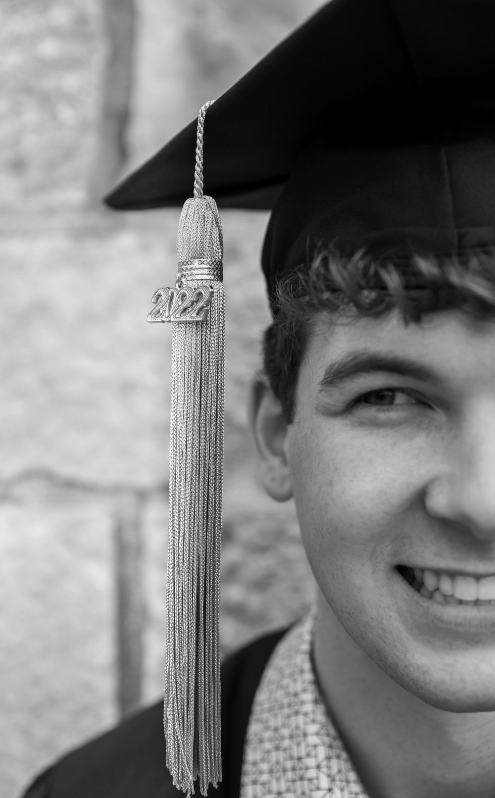Close-up of a graduation tassel with 2022 charm hanging from a mortarboard cap.