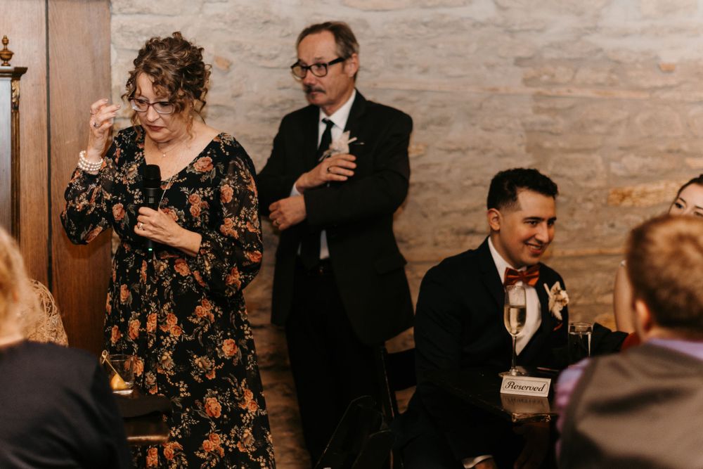 Wedding guests raising champagne glasses during a heartfelt toast at the reception.